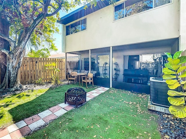 back of house with central air condition unit, stucco siding, a yard, and fence