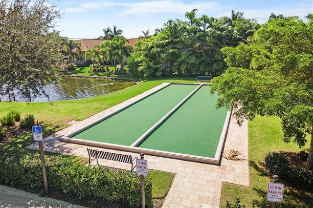 view of property's community featuring a lawn and a water view