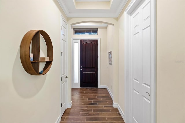 doorway featuring crown molding, baseboards, and wood tiled floor