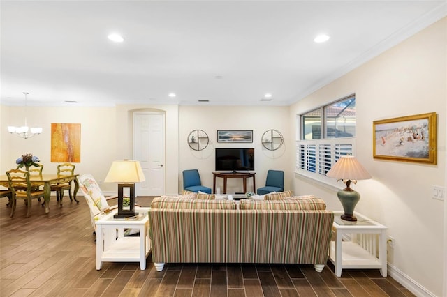 living area featuring baseboards, wood tiled floor, an inviting chandelier, recessed lighting, and ornamental molding