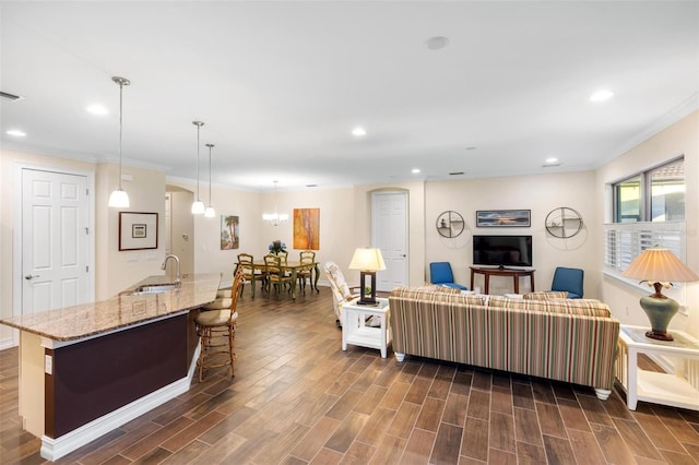 living area with dark wood-type flooring, recessed lighting, and crown molding