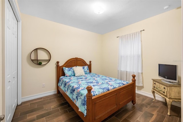 bedroom with wood finish floors, a closet, and baseboards