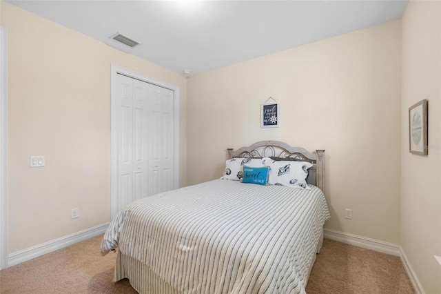 carpeted bedroom featuring visible vents, baseboards, and a closet