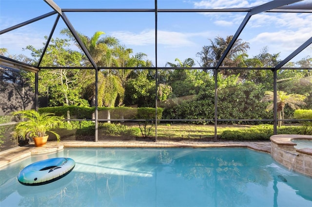 pool featuring glass enclosure and an in ground hot tub