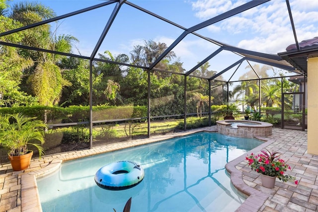 view of swimming pool featuring glass enclosure, a patio, and a pool with connected hot tub