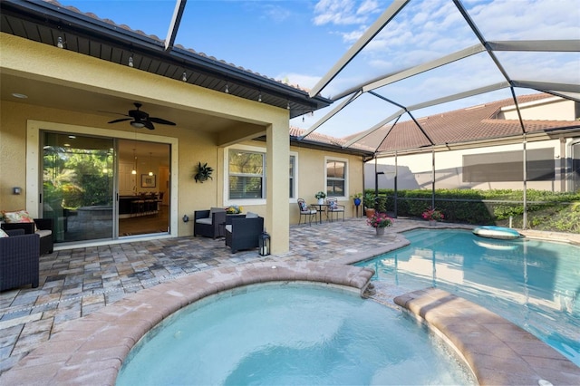 view of swimming pool with ceiling fan, a pool with connected hot tub, a lanai, and a patio area