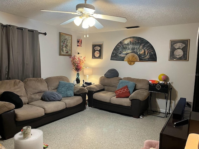 living area featuring visible vents, a textured ceiling, and ceiling fan