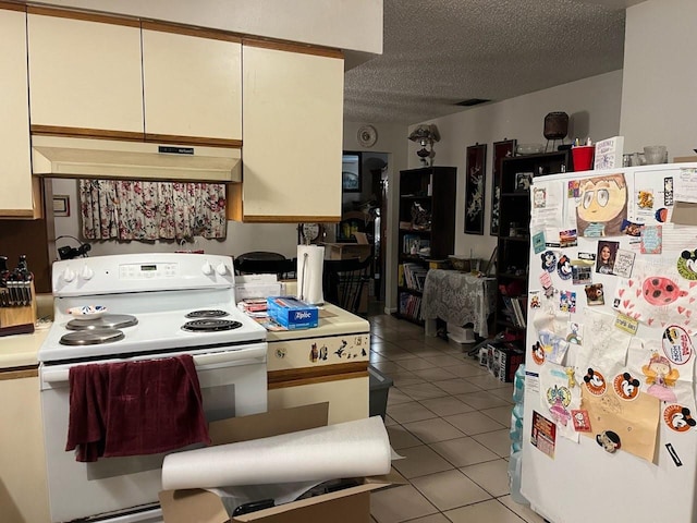 kitchen featuring white appliances, light tile patterned flooring, light countertops, under cabinet range hood, and a textured ceiling