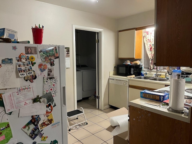 kitchen featuring light tile patterned floors, white appliances, light countertops, and a sink