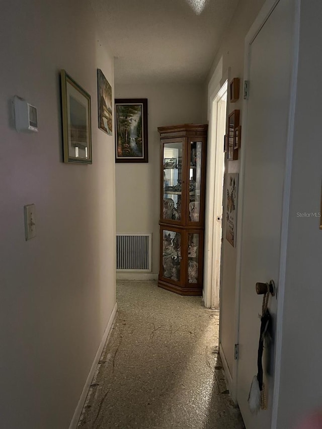 corridor with baseboards and visible vents