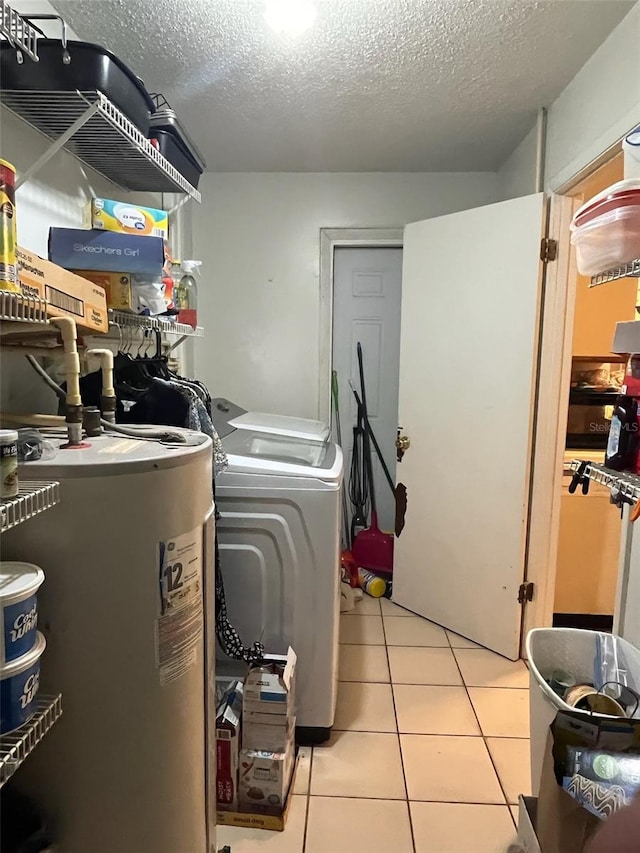 laundry area featuring light tile patterned floors, laundry area, a textured ceiling, independent washer and dryer, and electric water heater