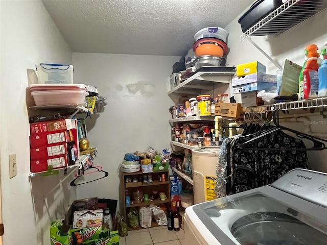 laundry area with laundry area, washer / clothes dryer, tile patterned floors, and a textured ceiling