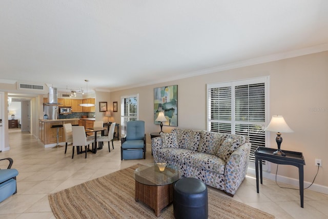 living area with light tile patterned floors, visible vents, baseboards, and crown molding