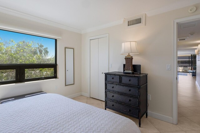 bedroom with light tile patterned flooring, baseboards, visible vents, and ornamental molding