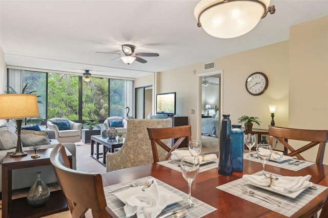 dining space with visible vents, a ceiling fan, and expansive windows