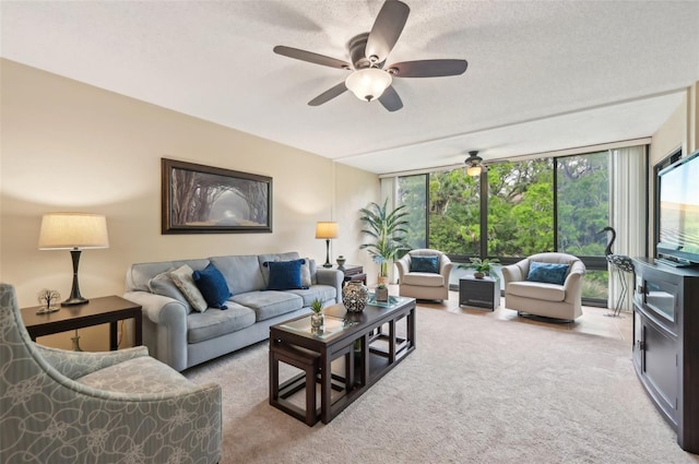 carpeted living room featuring a textured ceiling, a wall of windows, and ceiling fan