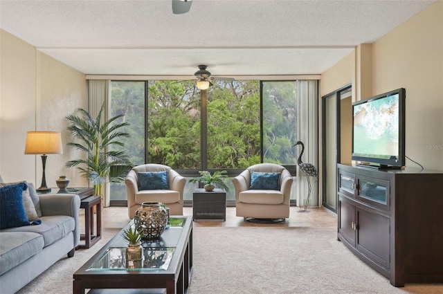 living room featuring a textured ceiling, floor to ceiling windows, light colored carpet, and a healthy amount of sunlight