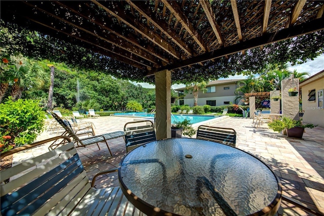 view of patio featuring outdoor dining space, a community pool, and a pergola