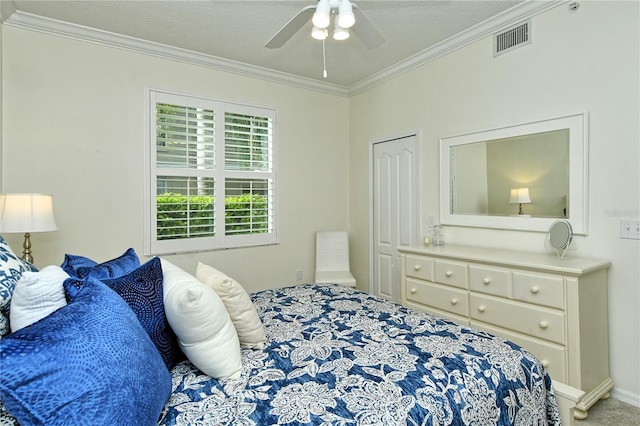 bedroom featuring visible vents, a textured ceiling, crown molding, and a ceiling fan