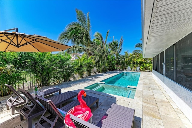 view of pool with a patio, a pool with connected hot tub, and a sunroom