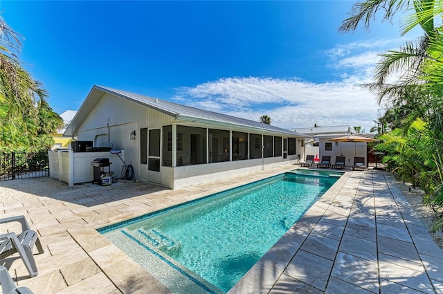 view of pool featuring grilling area, a fenced in pool, fence, a sunroom, and a patio