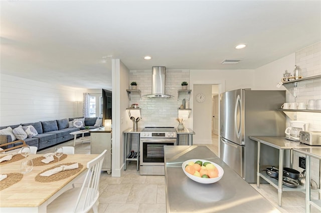 kitchen with open shelves, wall chimney exhaust hood, light countertops, and appliances with stainless steel finishes