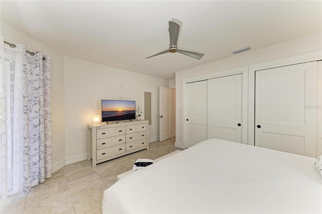 bedroom featuring visible vents, ceiling fan, baseboards, and multiple closets