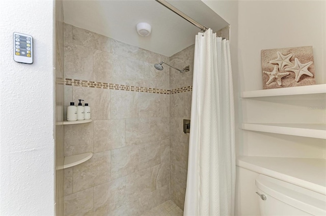 bathroom with toilet and tiled shower