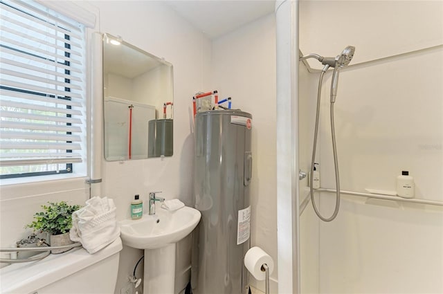 bathroom featuring a sink, electric water heater, a stall shower, and toilet