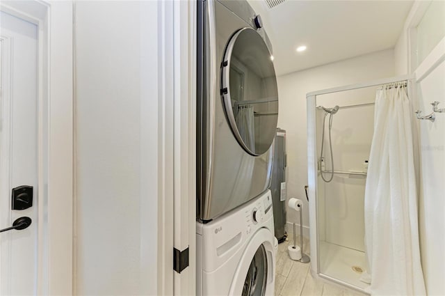 washroom featuring laundry area, recessed lighting, stacked washer and dryer, electric water heater, and light wood-type flooring