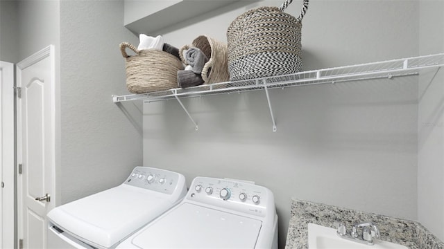 clothes washing area with a sink, laundry area, and washing machine and clothes dryer