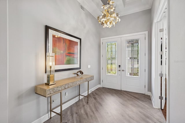 foyer entrance with visible vents, baseboards, french doors, wood finished floors, and a notable chandelier