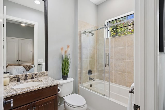 full bath featuring vanity, toilet, bath / shower combo with glass door, and ensuite bathroom