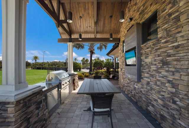 view of patio featuring grilling area, fence, and an outdoor kitchen