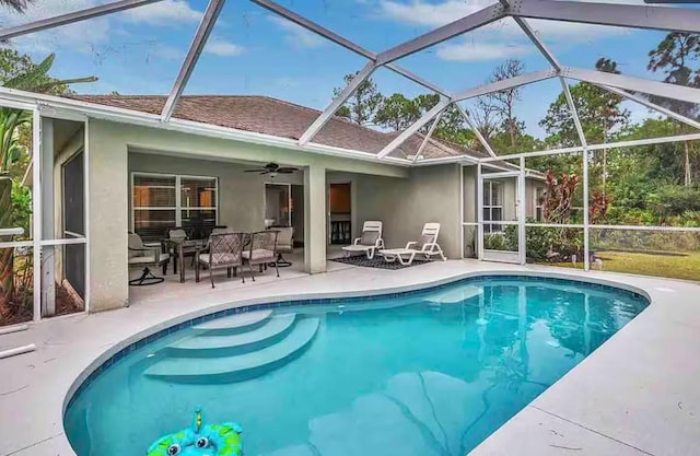 outdoor pool with a patio, a ceiling fan, and a lanai