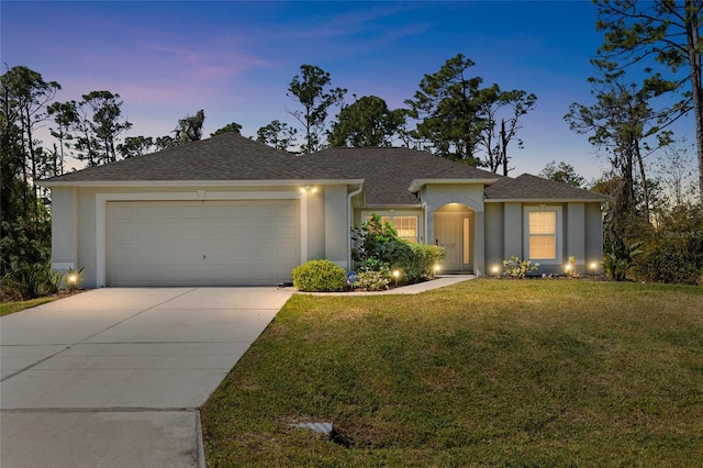 ranch-style home featuring stucco siding, driveway, a yard, a shingled roof, and a garage