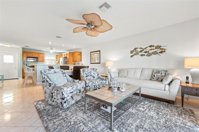 living room with light tile patterned floors, visible vents, baseboards, and a ceiling fan