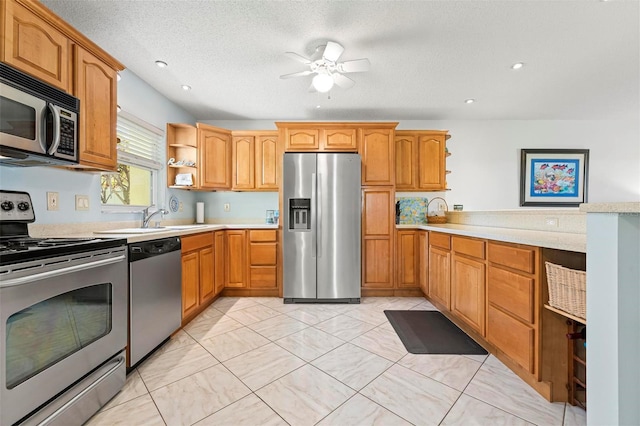 kitchen with light countertops, appliances with stainless steel finishes, a peninsula, a textured ceiling, and open shelves