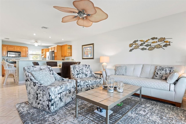 living area with light tile patterned floors, visible vents, and ceiling fan