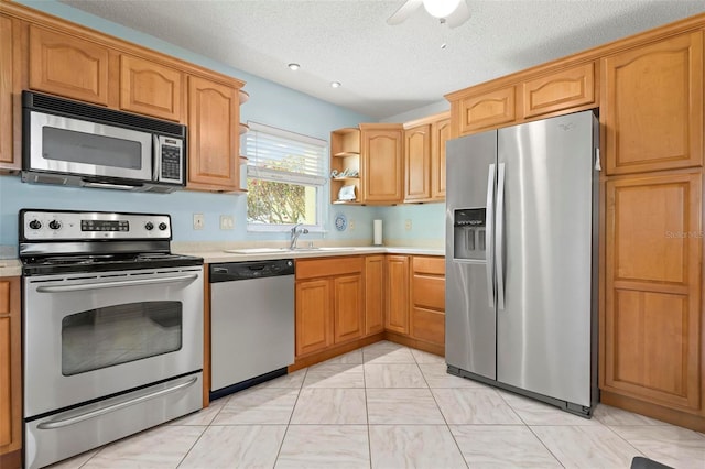 kitchen with marble finish floor, a ceiling fan, open shelves, appliances with stainless steel finishes, and light countertops