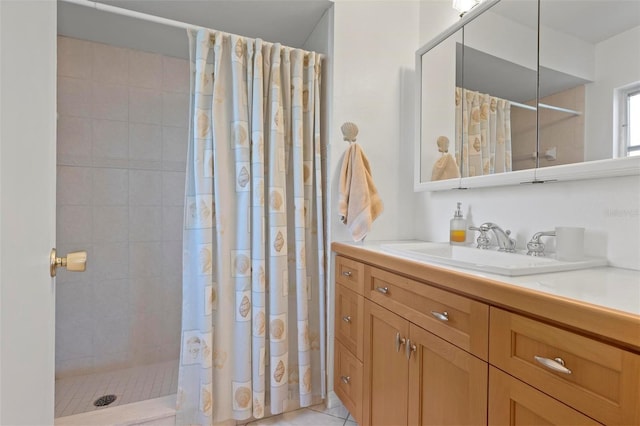 full bathroom featuring a tile shower, tile patterned flooring, and vanity