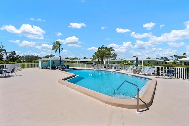 community pool with fence and a patio area