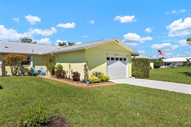 view of side of property featuring a yard, concrete driveway, and a garage