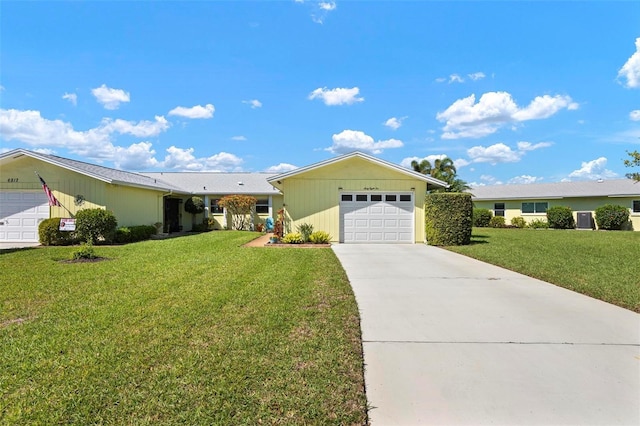 ranch-style house featuring an attached garage, driveway, and a front yard