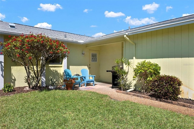 doorway to property with a yard and a patio