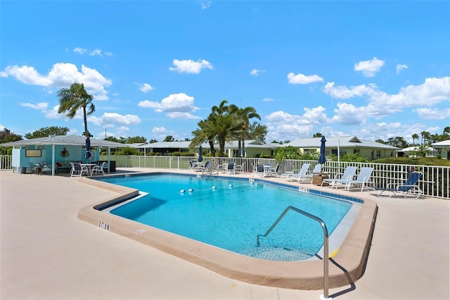 pool with a patio area and fence