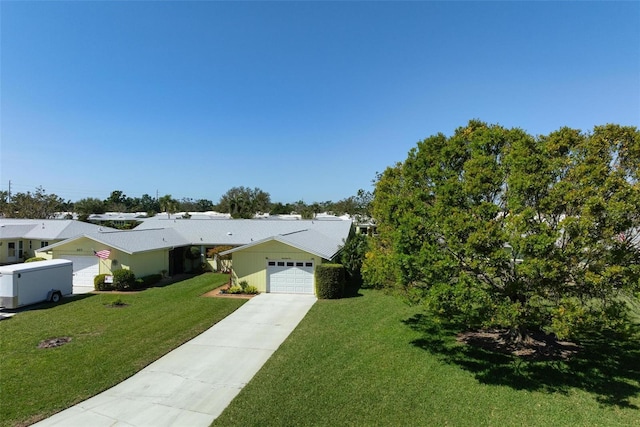 view of front of house with concrete driveway, a garage, and a front yard