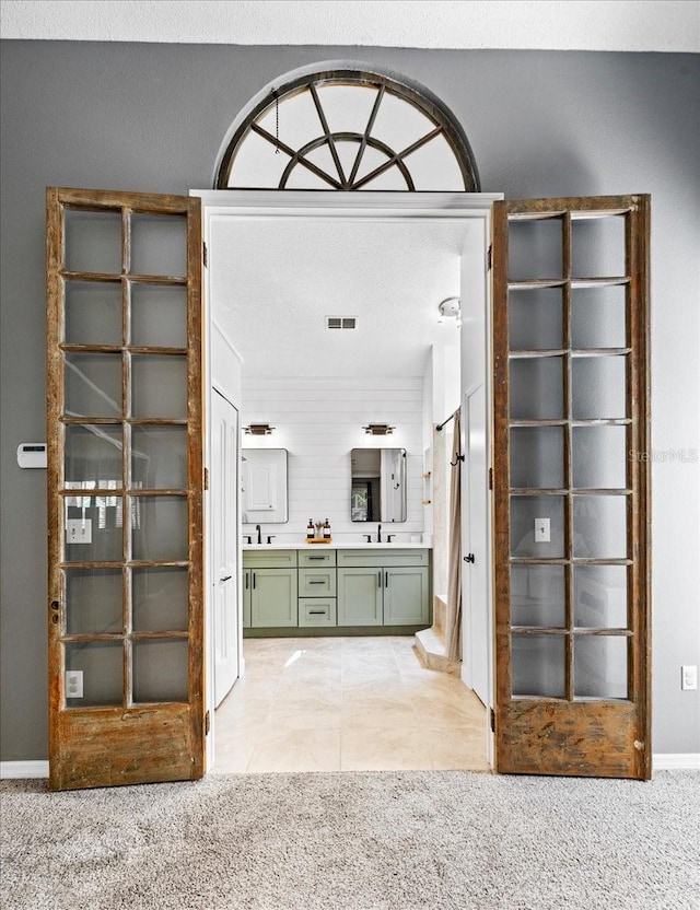 bathroom with tile patterned floors, double vanity, visible vents, and a sink