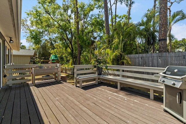 wooden deck with a fenced backyard and grilling area