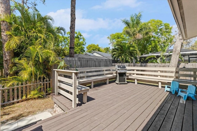 wooden terrace featuring grilling area and a fenced backyard